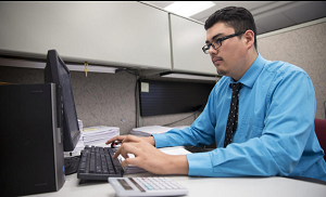This photo shows a boy working one day per week. Didier Garcia, age 18, is a senior at a Cristo Rey School, the St. Martin College Prep in Waukegan, Illinois.  He labors on inputting invoice information at Stepan Chemical in Northbrook (Tuesday, Sept. 15, 2015).  One notes his professional appearance, shirt and tie, and attention, learned by working and earning most of his own school tuition. Note also his opportunity to attend a Catholic school even though he come’s from a poor family.