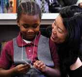 Rhee visits with first grader Sasha Simpson.