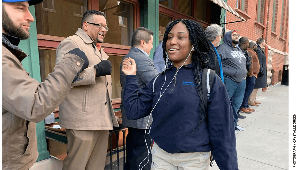 Green recruited a group of young professional men from the community to greet students outside on the sidewalk as they arrive for the day. The middle- and and high-school students walk a gauntlet of fist bumps and high-fives on the way into the school.