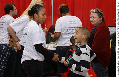 A potential student speaks with a Sylvanie Williams College Prep representa- tive at the Schools Expo hosted by the Urban League of Greater New Orleans