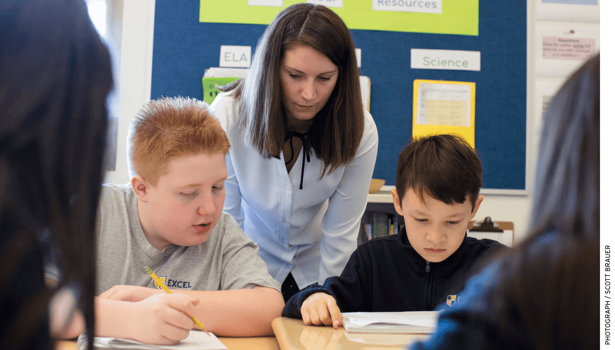 Samantha Butera, a 6th-grade learning specialist at Excel Academy East Boston, works with two students.