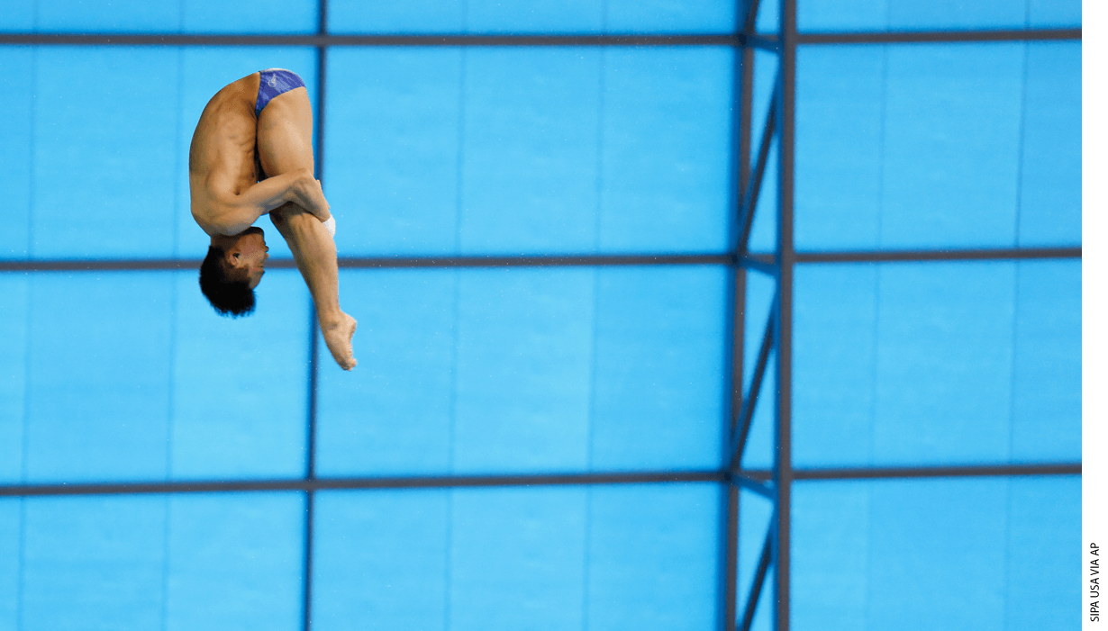 A diver in mid-flip heading down towards the pool.