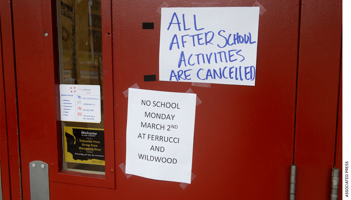 A red door with posted signs that read "All After School Activities Cancelled" and "No School Monday March 2nd"
