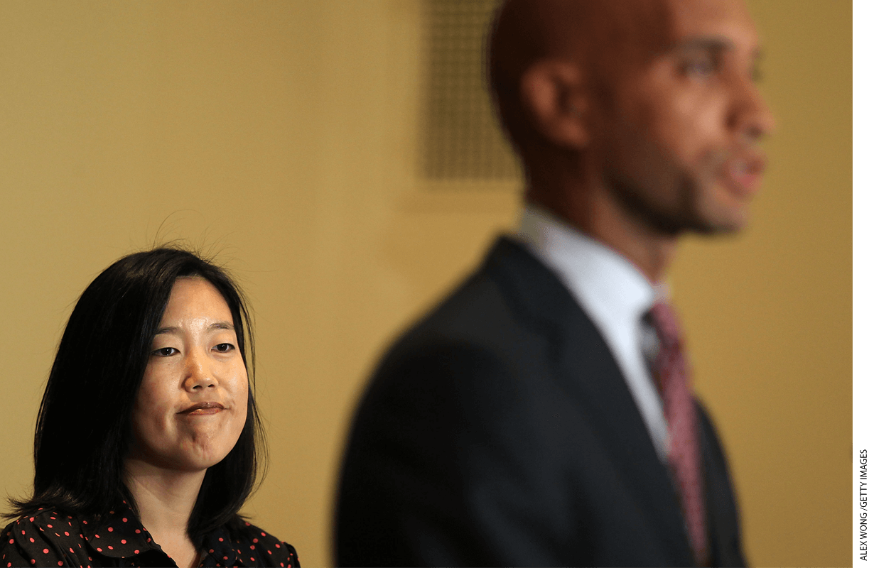 Chancellor Michelle Rhee (left) listens as Mayor Adrian Fenty speaks during a 2010 news conference at the end of her tenure.
