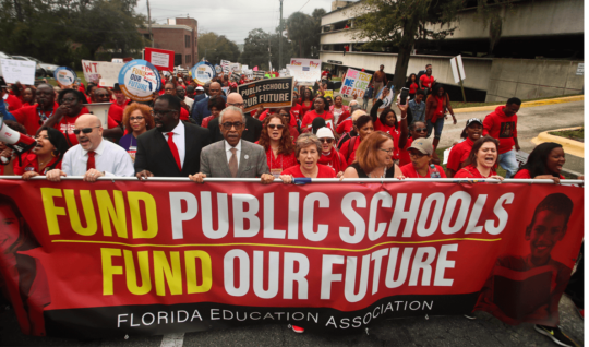 The Rev. Al Sharpton, front center, leads protestors as they march Monday, Jan. 13, 2020, during the Florida Education Association's "Take on Tallahassee" rally at the Old Capitol in Tallahassee, Fla.