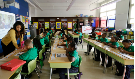 Teacher Shanel Sommers looks over the work of one of her third-graders at KIPP Thrive Academy in Newark, N.J.