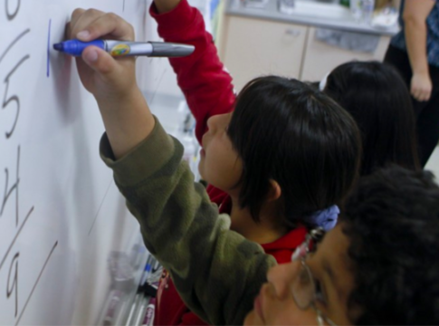 Students working on math problems on a white board