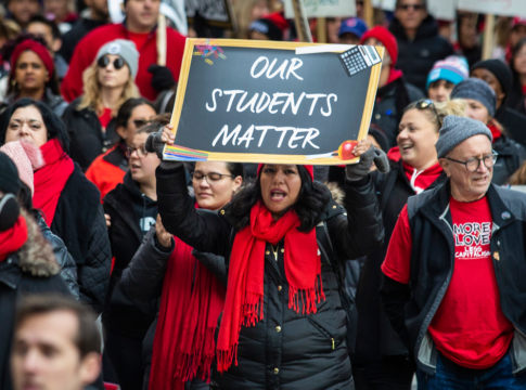 Thousands of striking Chicago Teachers Union and their supporters march around City Hall in October 2019. One person in front holds up a sign that reads, "Our Students Matter."