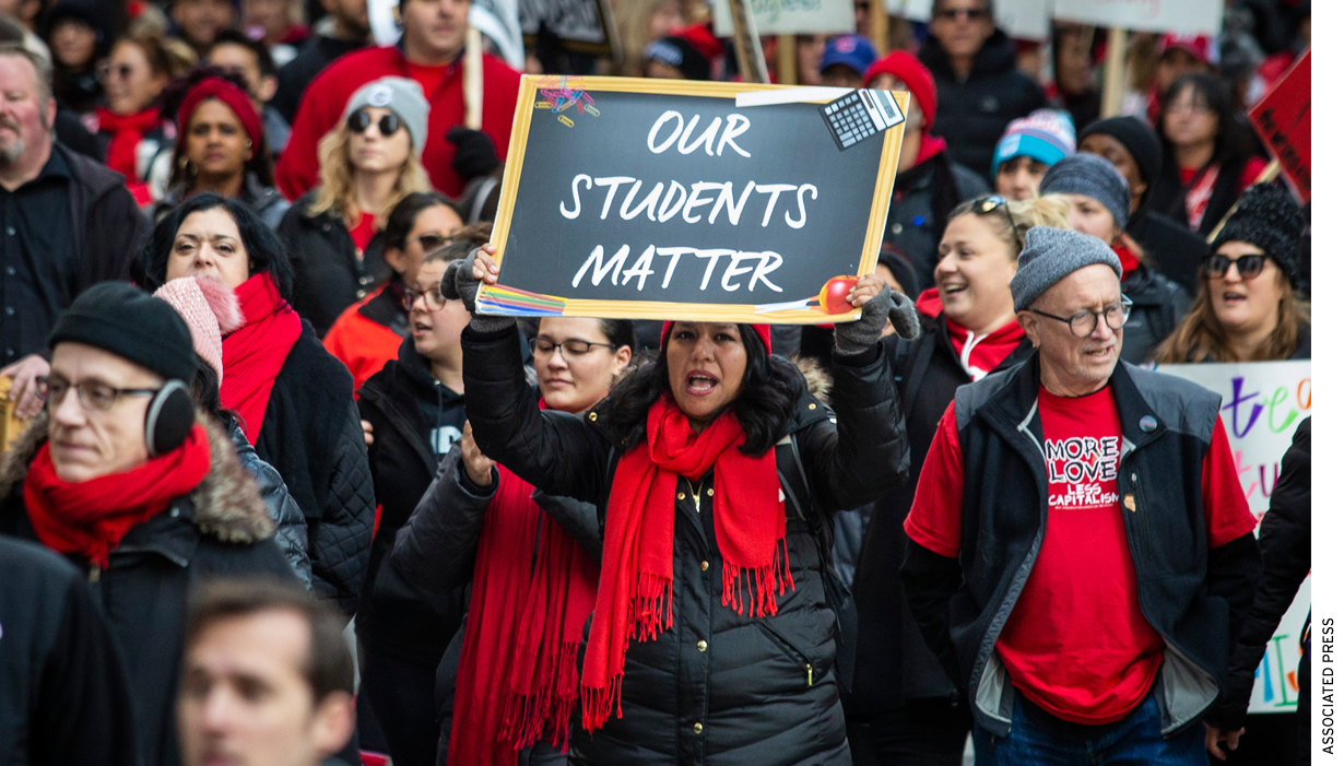 Thousands of striking Chicago Teachers Union and their supporters march around City Hall in October 2019. One person in front holds up a sign that reads, "Our Students Matter."