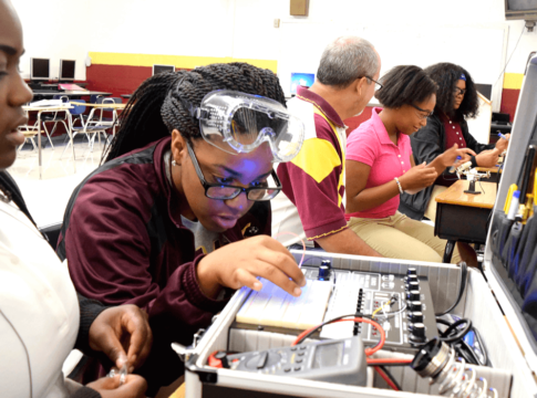 Training for high-tech: In Chattanooga, Tennessee, Tyner Academy students (from left) Jada Beckett and Takayla Sanford work on building circuits, while “mechatronics” teacher Bryan Robinson instructs Brookeana Willams and Noemy Marberry about soldering.