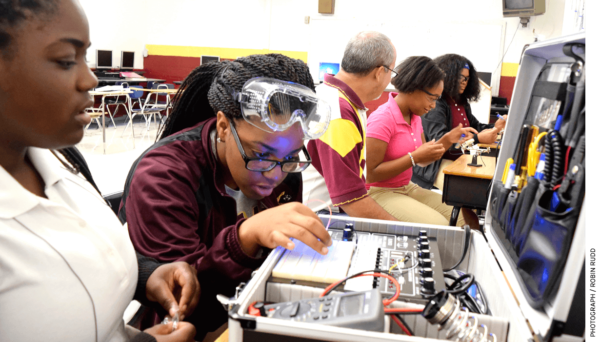 Training for high-tech: In Chattanooga, Tennessee, Tyner Academy students (from left) Jada Beckett and Takayla Sanford work on building circuits, while “mechatronics” teacher Bryan Robinson instructs Brookeana Willams and Noemy Marberry about soldering.