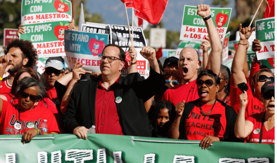 The president of United Teachers Los Angeles, Alex Caputo-Pearl, center, joins unionized teachers at a rally in the city in 2018.