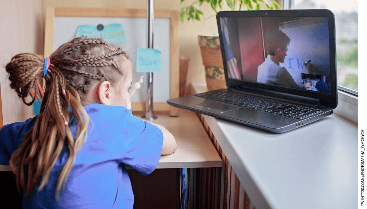 A child following along with a teacher on a laptop, during a distance learning lesson.