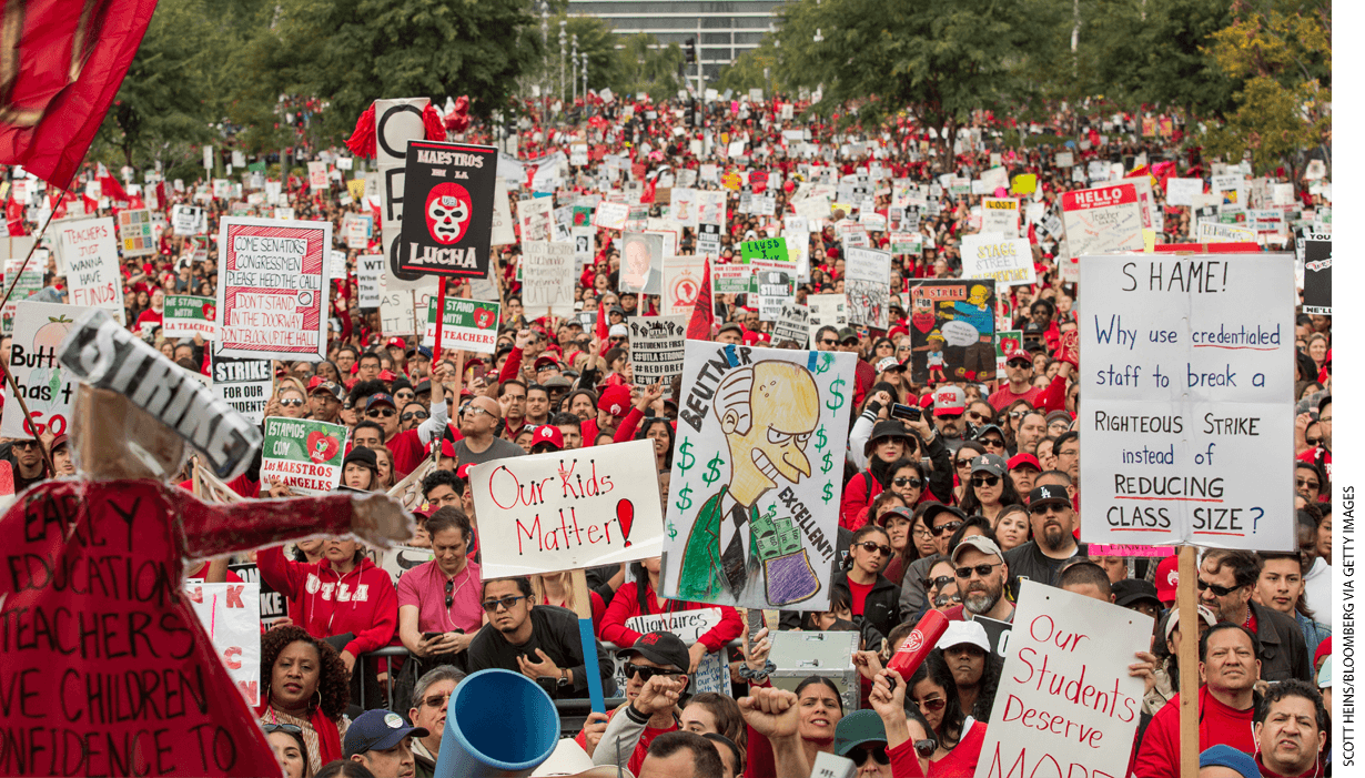 Demonstrators hold signs during a teacher strike in Los Angeles, California, on Friday, Jan. 18, 2019.
