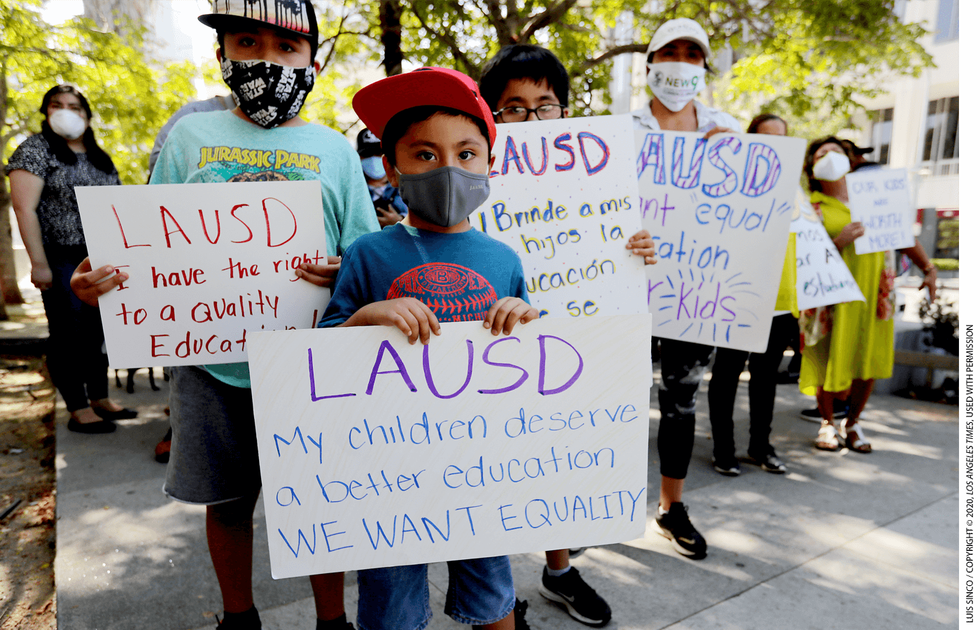 Student holds a sign outside a news conference that reads "LAUSD: My children deserve a better education WE WANT EQUALITY"