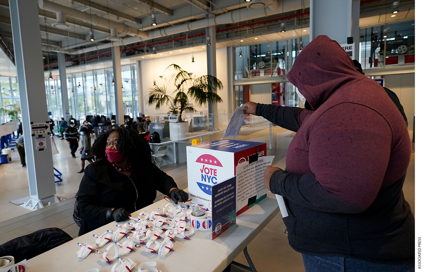 A voter drops his absentee ballot into a box on the last day of early voting in New York City, November 1, 2020.