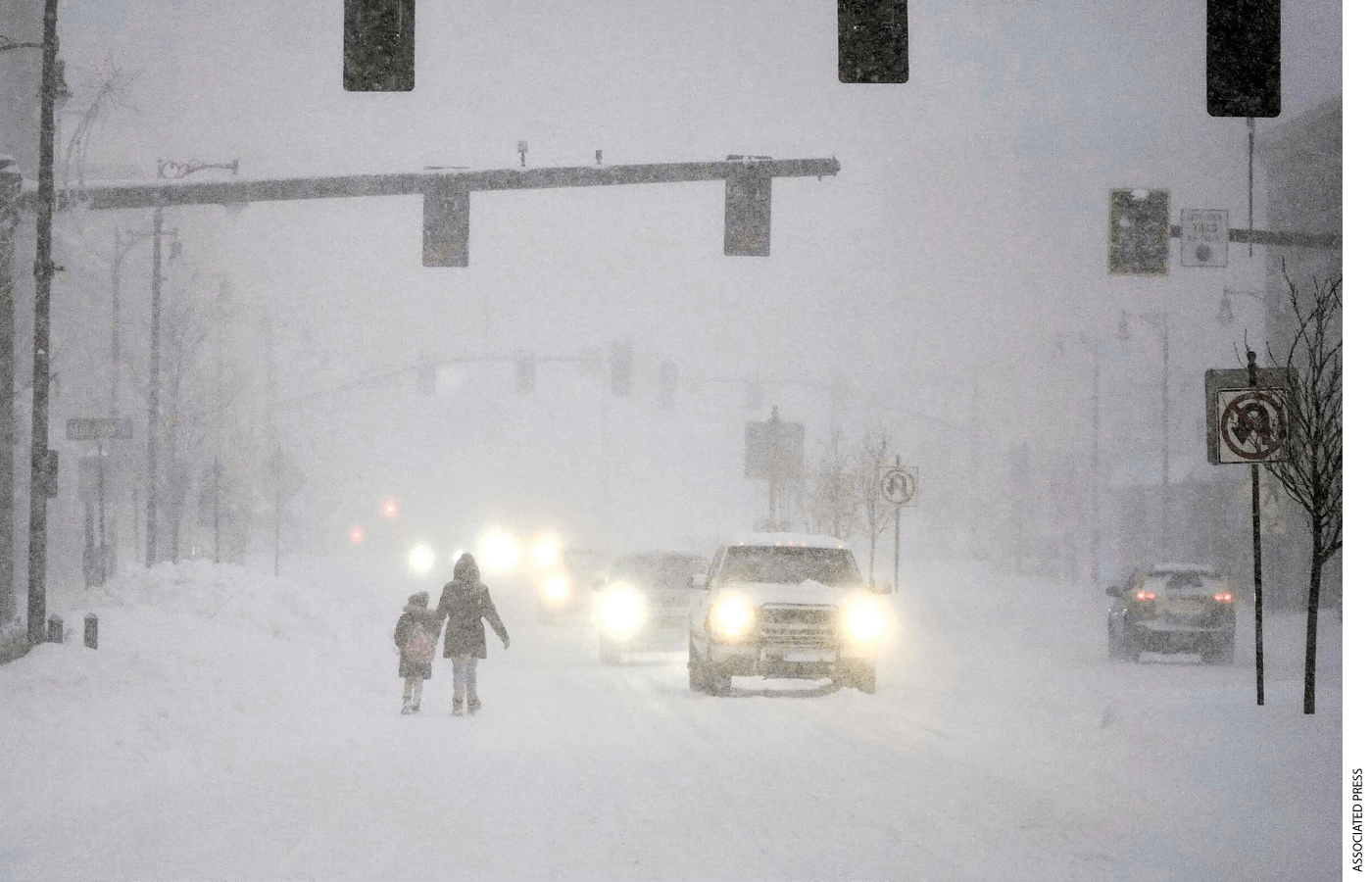 Pedestrians walk along North Street in Pittsfield, Mass, early Thursday, Dec. 17, 2020