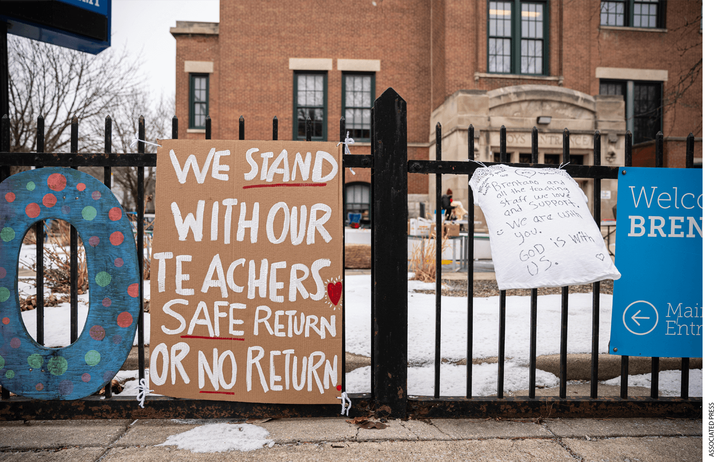 Banners in support of the elementary school teachers hang outside Brentano Elementary School as teachers instruct virtual classes during a protest against returning to in-person teaching outside of Brentano Elementary School in Chicago, Monday, Jan. 4, 2021.