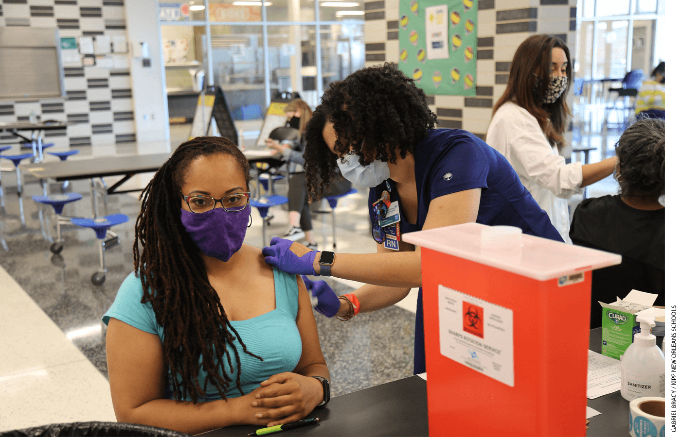 A woman receives a Covid-19 vaccine in a school