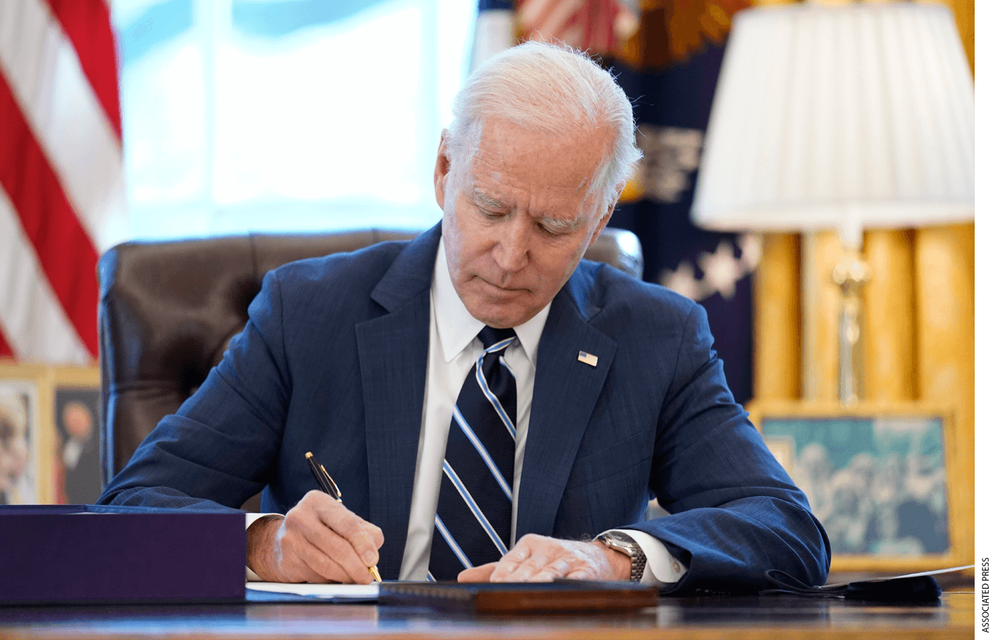 President Joe Biden signs the American Rescue Plan, a coronavirus relief package, in the Oval Office of the White House, Thursday, March 11, 2021.