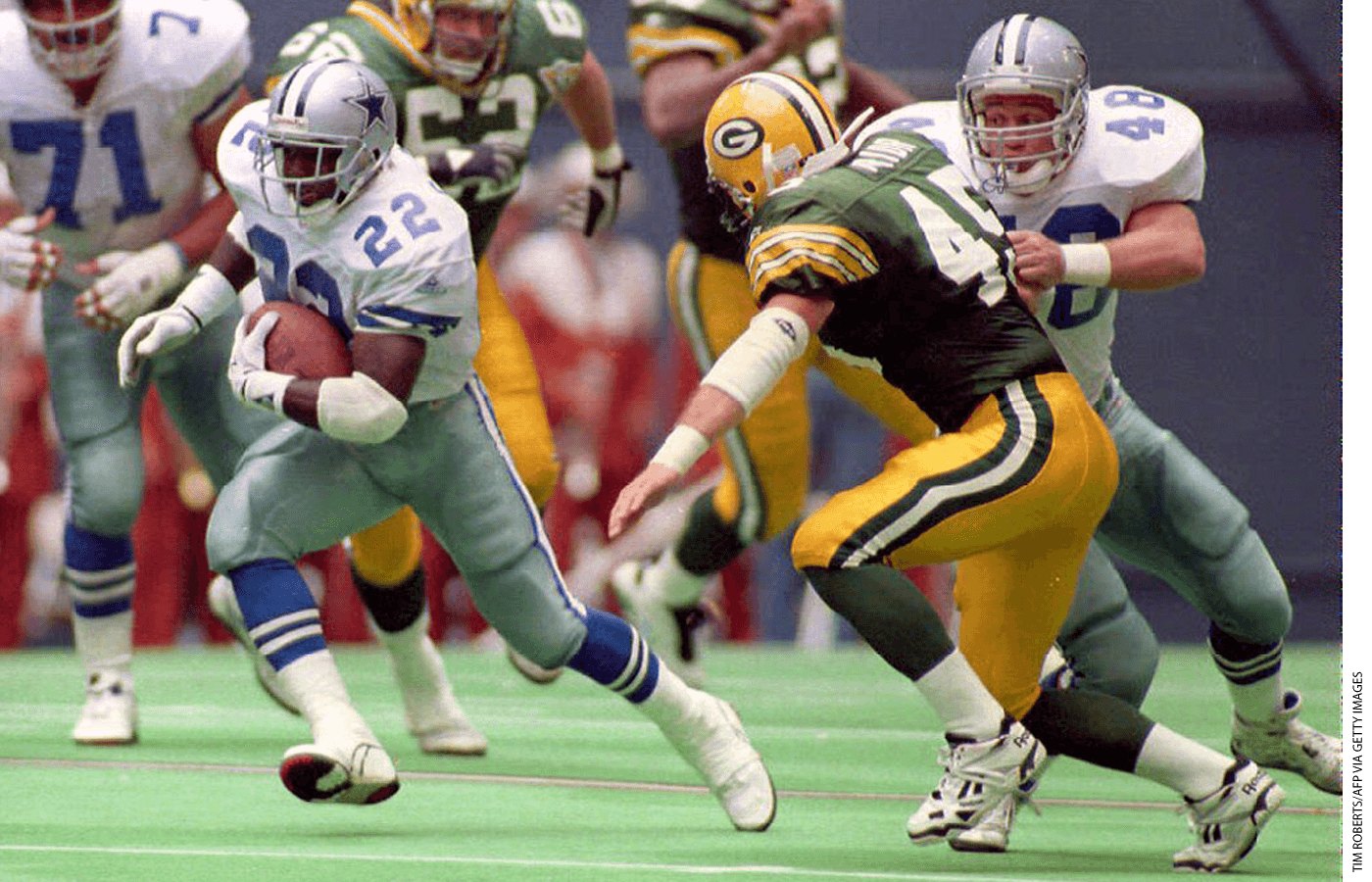 Dallas Cowboys running back Emmitt Smith (22) cuts around teammate Daryl Johnston (48) as Johnston makes a block on Green Bay Packers safety Mike Prior (45) during second quarter action 03 October 1993.