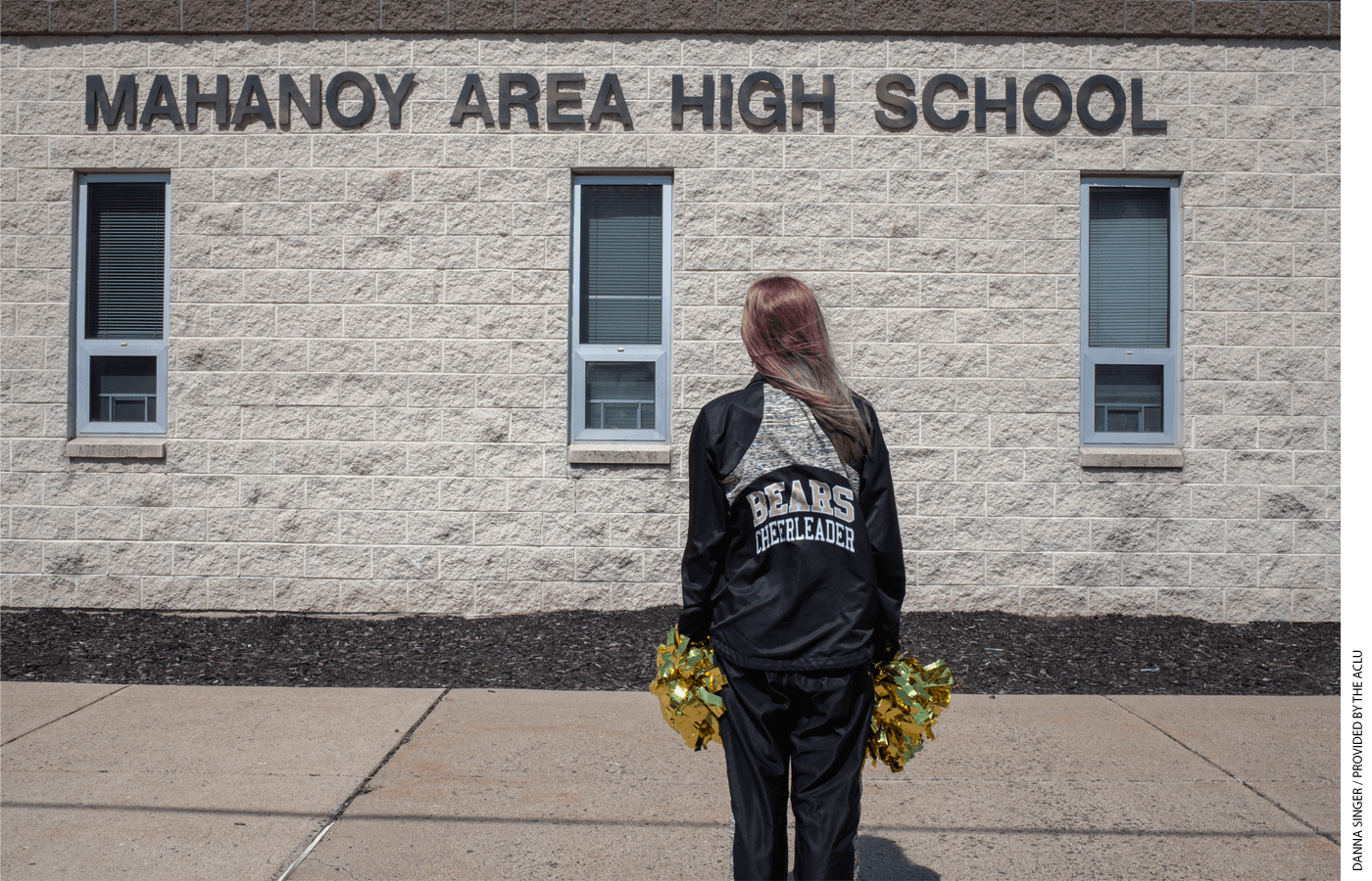 Cheerleader stands in front of Mahanoy Area High School