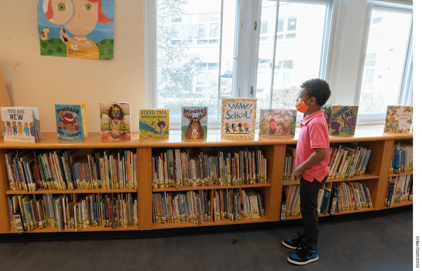 A first grader picks out a book he would like to check out at the Post Road Elementary School Library, Thursday, Oct. 1, 2020, in White Plains, N.Y.