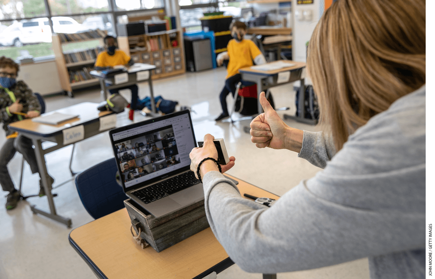 Third-grade teacher Cara Denison manages students in person and remotely, simultaneously, at Rogers International School in Stamford, Connecticut.