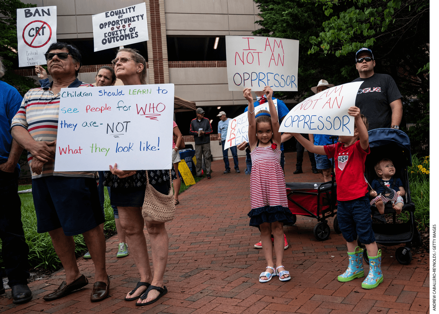 People hold up signs during a rally against "critical race theory" being taught in schools. The rally was at the Loudoun County Government center in Leesburg, Virginia on June 12, 2021.