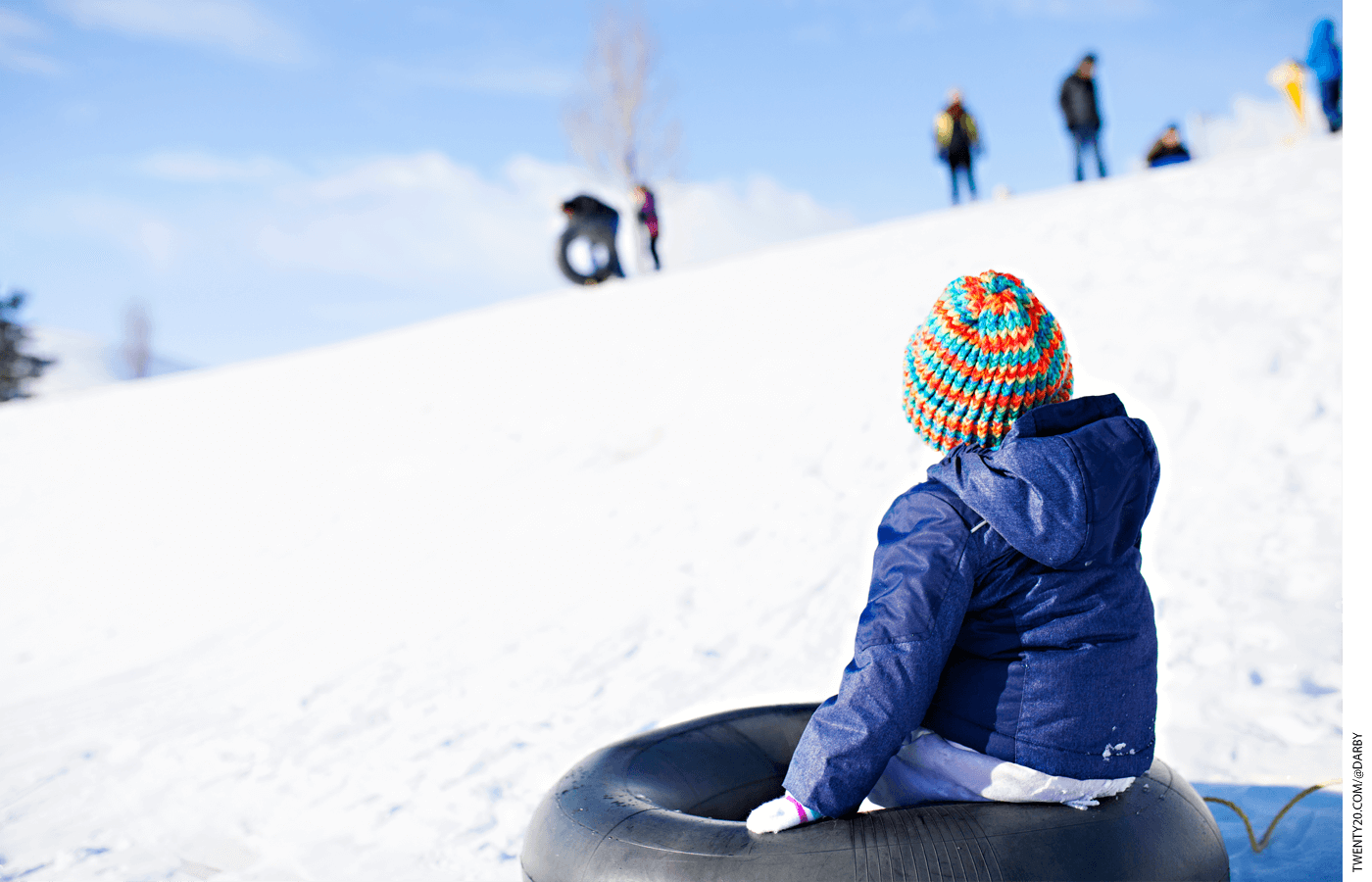 Kid sitting on a tube in the snow