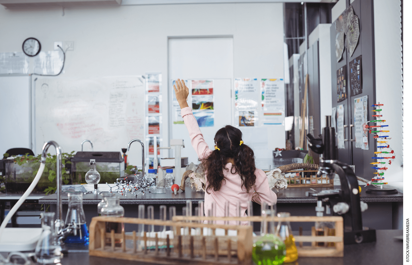 Student raising hand in a science lab