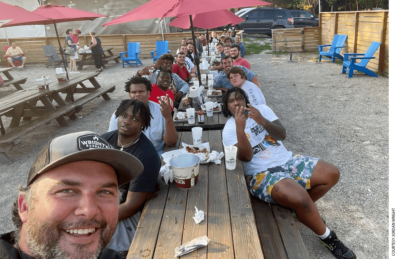 Jordan Wright, shown front bottom left, owner of Wright’s Barbecue, a popular Arkansas restaurant, is sponsoring the entire offensive line of the University of Arkansas Razorbacks men’s football team.