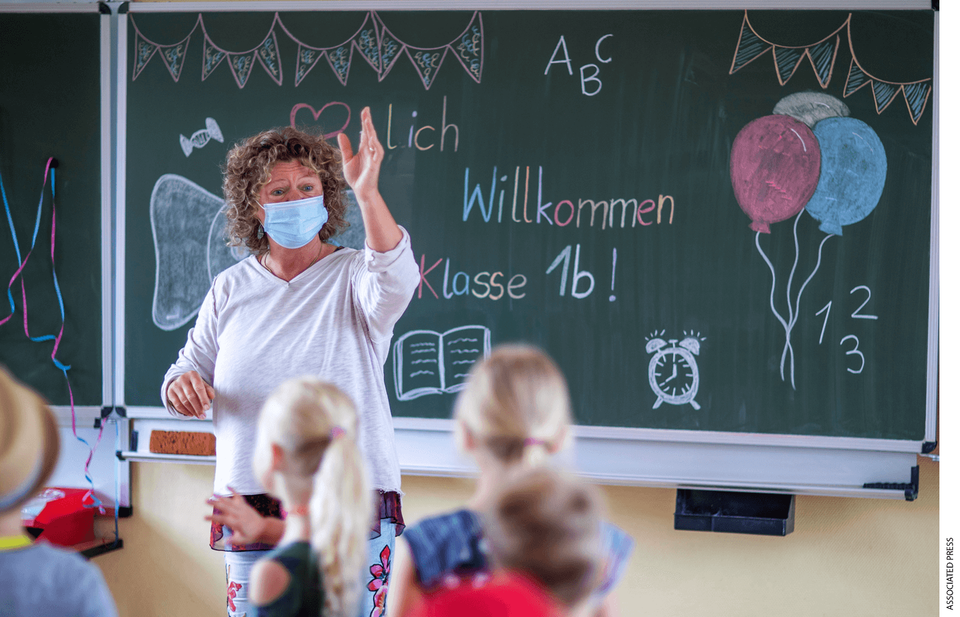 Teacher Ditte M'ller welcomes the pupils of class 1b in front of the blackboard in the classroom of the primary school "Werner Lindemann" on the first day of school in Mecklenburg-Western Pomerania, Germany, Aug. 2, 2021.