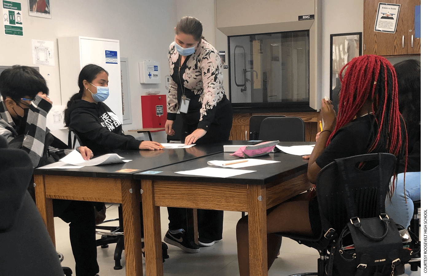 Begaeta Ahmic, a math teacher at Roosevelt High School, helps students with their work.