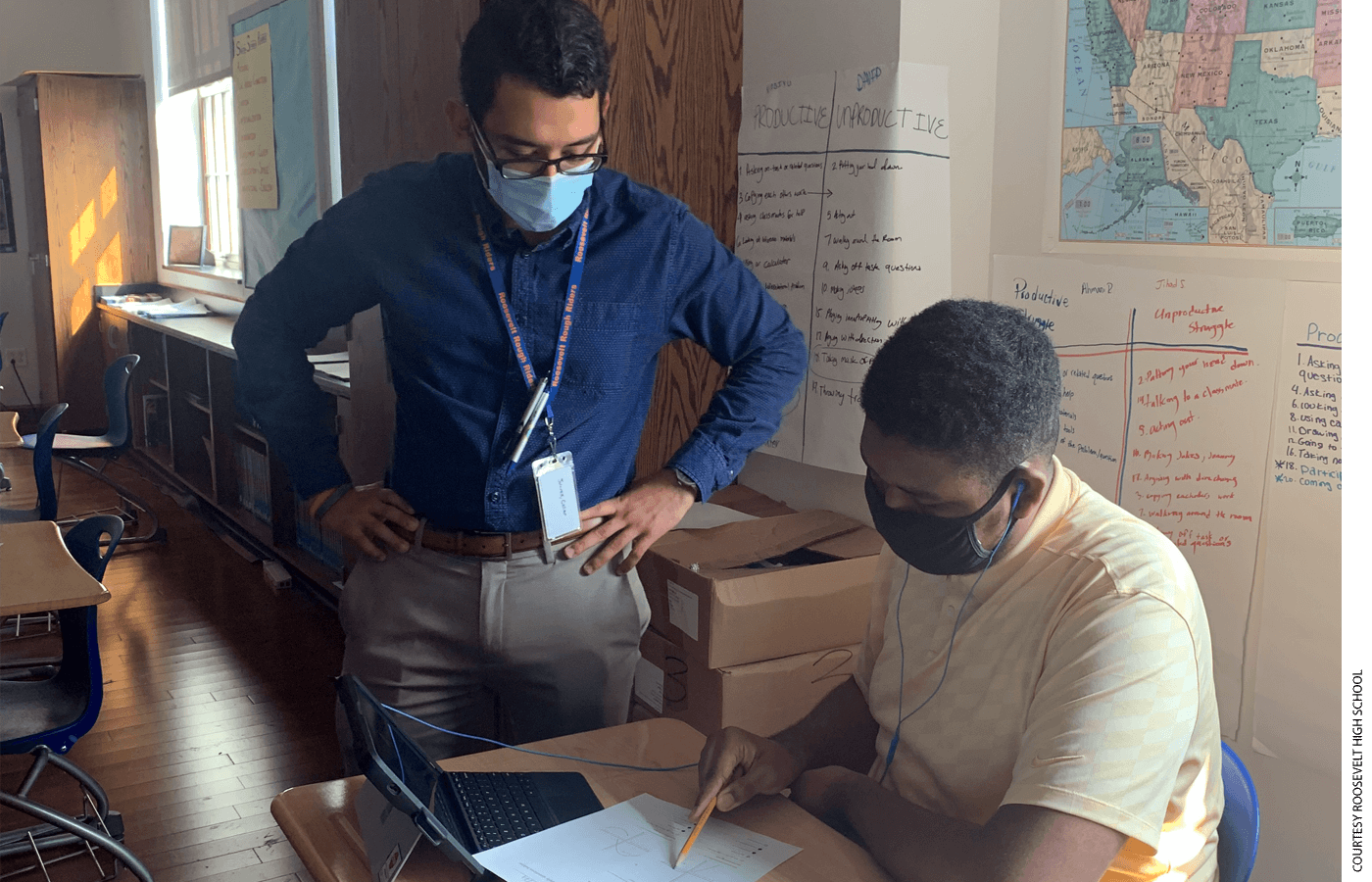Roosevelt High math teacher Juarez Cesar helps a student with his work.