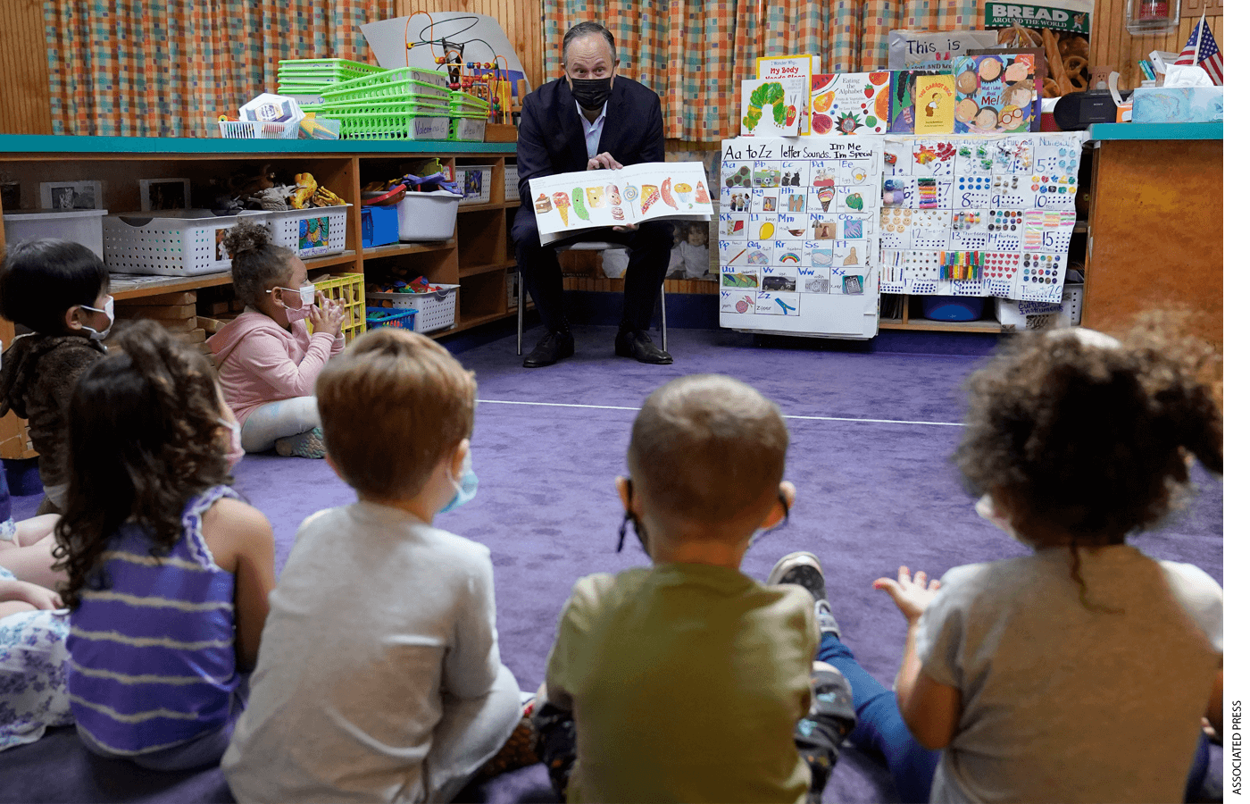 Douglas Emhoff, center, husband of Vice President Kamala Harris, reads The Very Hungry Caterpillar, by Eric Carle, to a group of pre-school children at Mother Hubbard Pre-School Center, Monday, Sept. 20, 2021, in Milford, Mass. Emhoff visited the child care center to draw attention to the Biden administration's Build Back Better agenda.