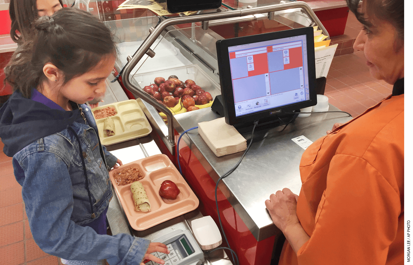 Third grader Eliana Vigil checks out in the lunch line at the Gonzales Community School in Santa Fe.