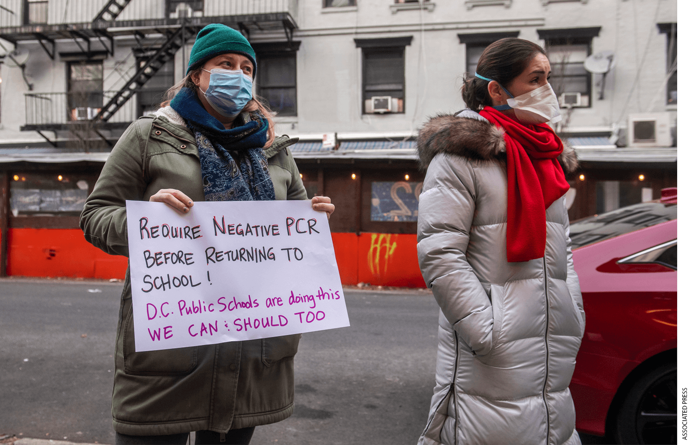 Kim Fritschy, left, is joined by other teachers calling for increased Covid-19 testing outside P.S. 64 Earth School Tuesday, Dec. 21, 2021, in New York.