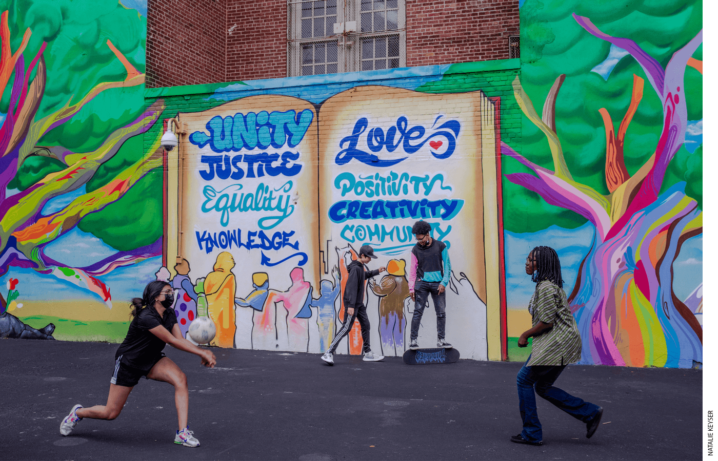 Students play in the school yard of Manhattan’s Bard High School Early College during recess. The mural behind them was painted by Elroy Gay and his team. Students chose the eight words at the mural’s center, which represent important ideas and their core values.