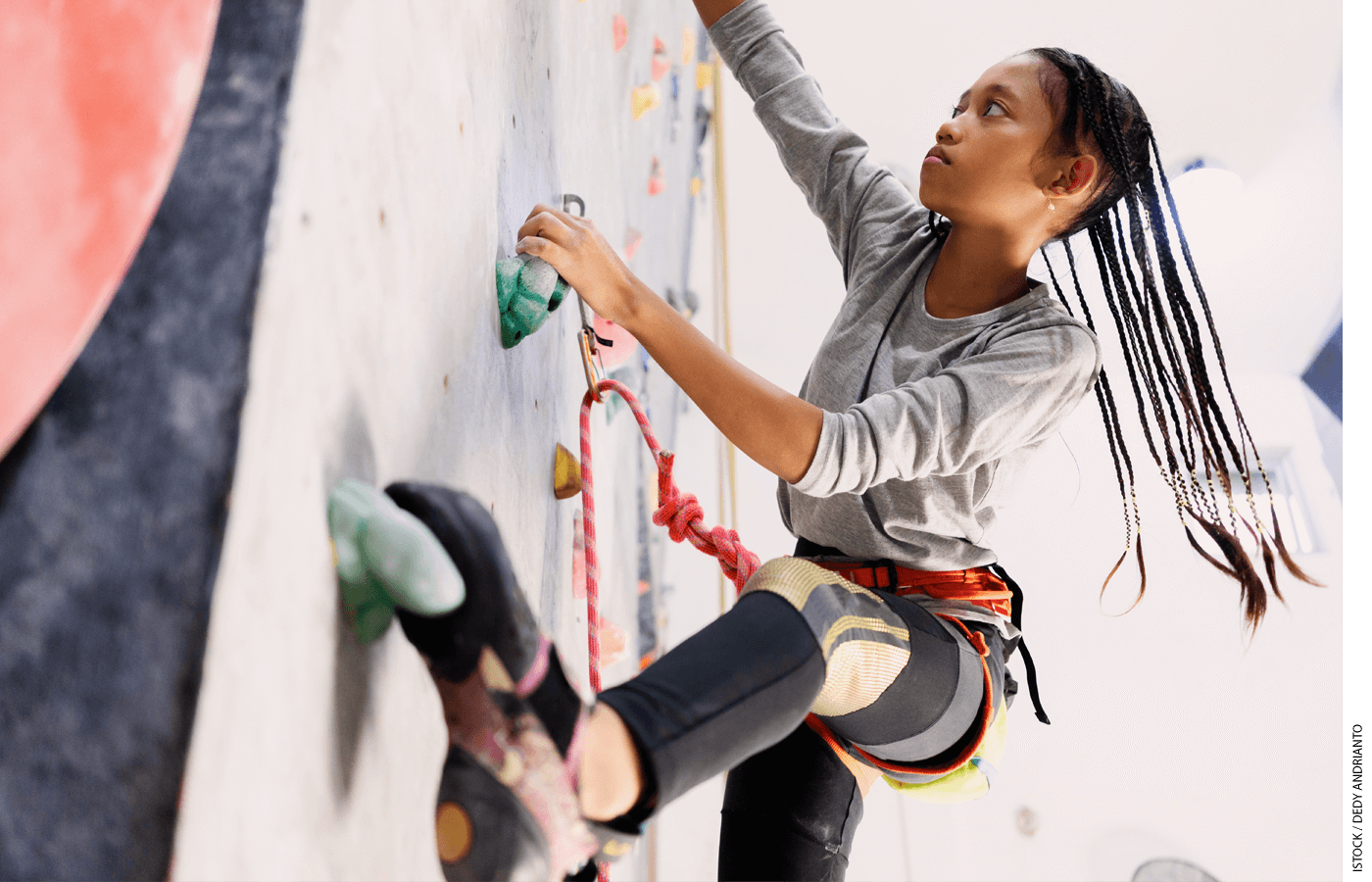 A girl climbs a rock wall