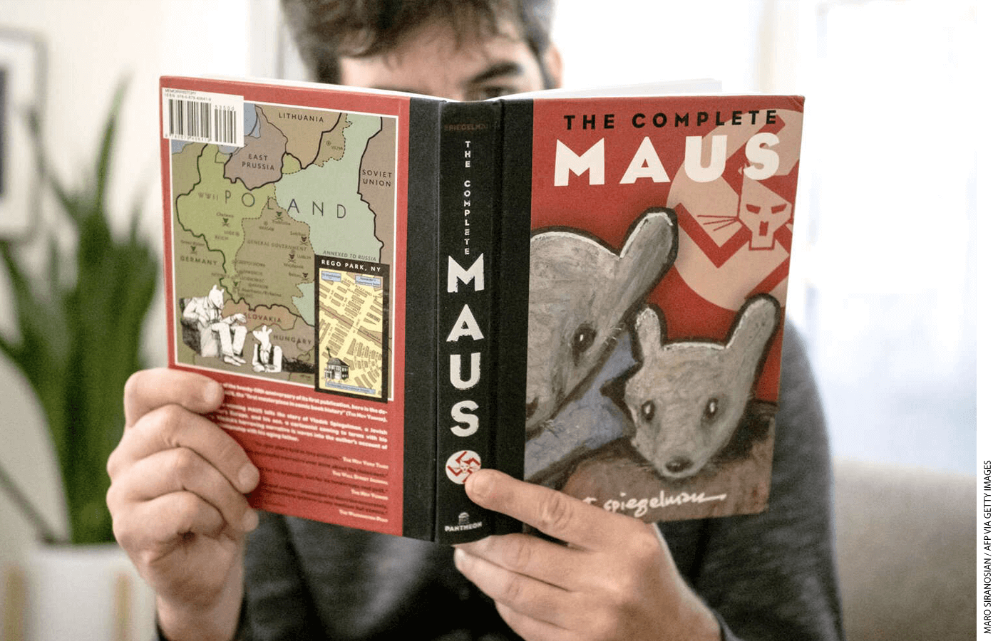 A man reads a copy of Maus by Art Spiegelman