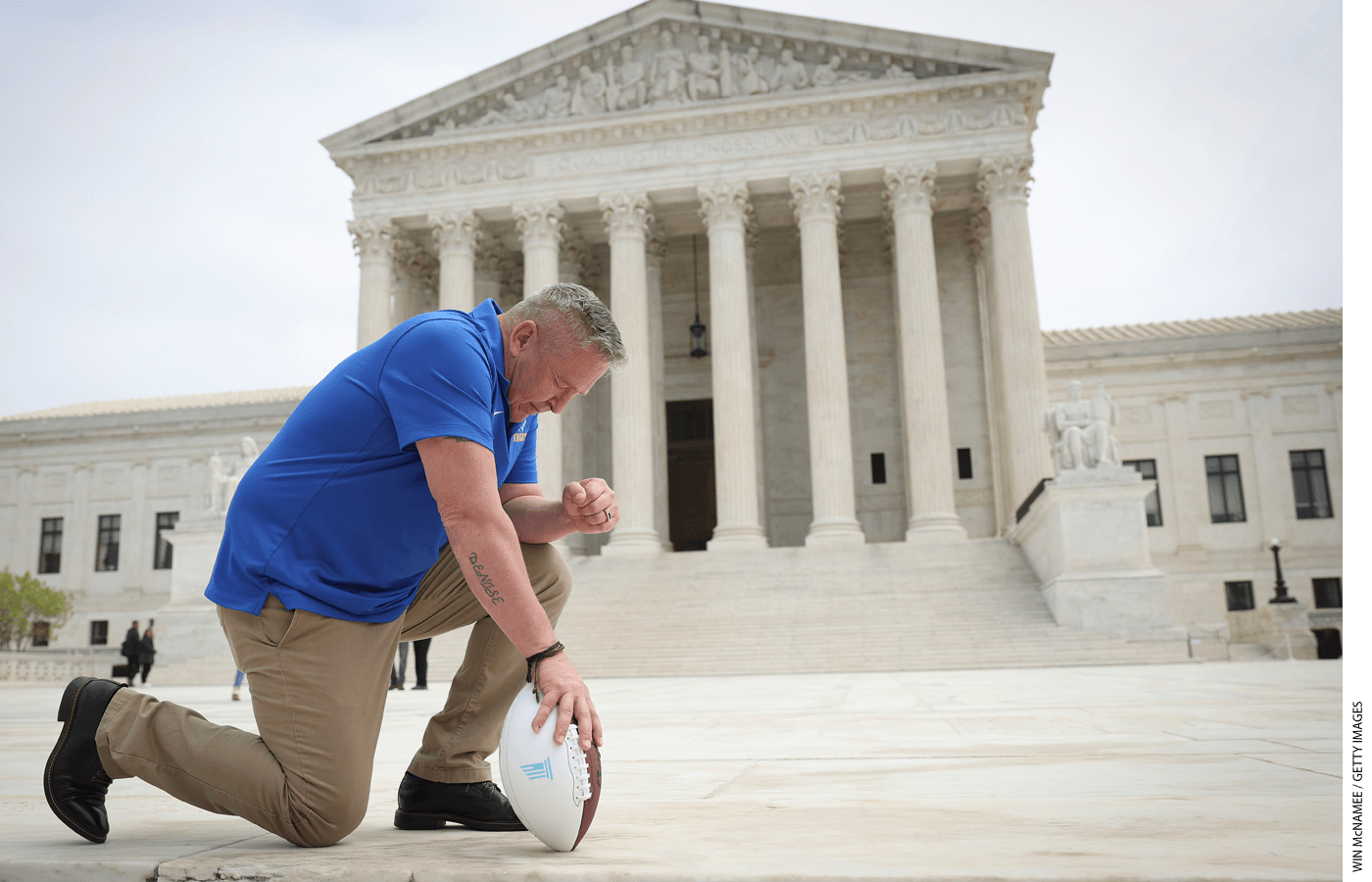 Former Bremerton High School assistant football coach Joe Kennedy takes a knee in front of the U.S. Supreme Court after his legal case, Kennedy vs. Bremerton School District, was argued before the court on April 25, 2022 in Washington, DC.