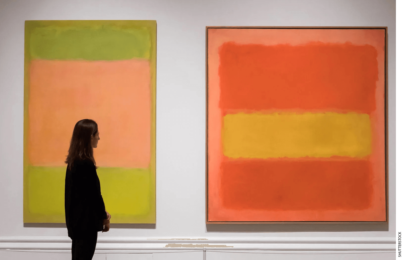 A person stands in front of two Mark Rothko paintings