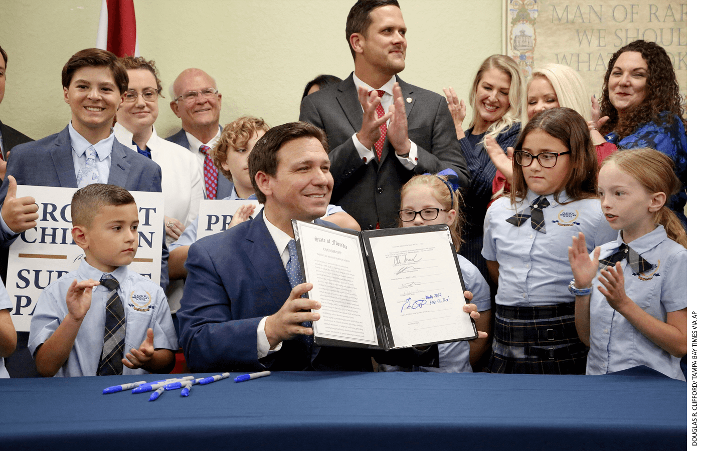 DeSantis displays the Parental Rights in Education Act he signed into law in March 2022 at Classical Preparatory School in Shady Hills. Opponents dub it the “Don’t Say Gay” law.
