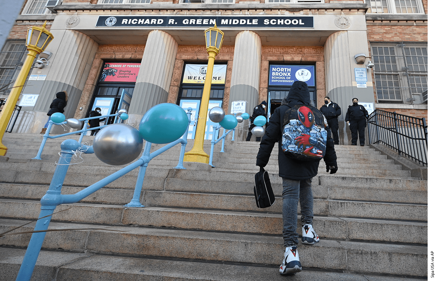 A student climbs the steps at Richard R. Green Middle School in the Bronx borough of New York City, February 25, 2021.
