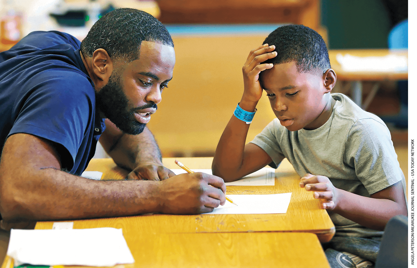 Marquise Mayes, 8, works on math homework with his teacher at Lloyd Barbee Montessori School in Milwaukee, Wisconsin.