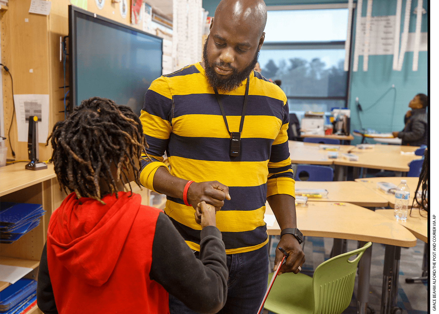 Teacher Tyler White congratulates a 4th-grade student at Stono Park Elementary School in Charleston, South Carolina. The county aims to hire 60 more Black teachers by 2025.
