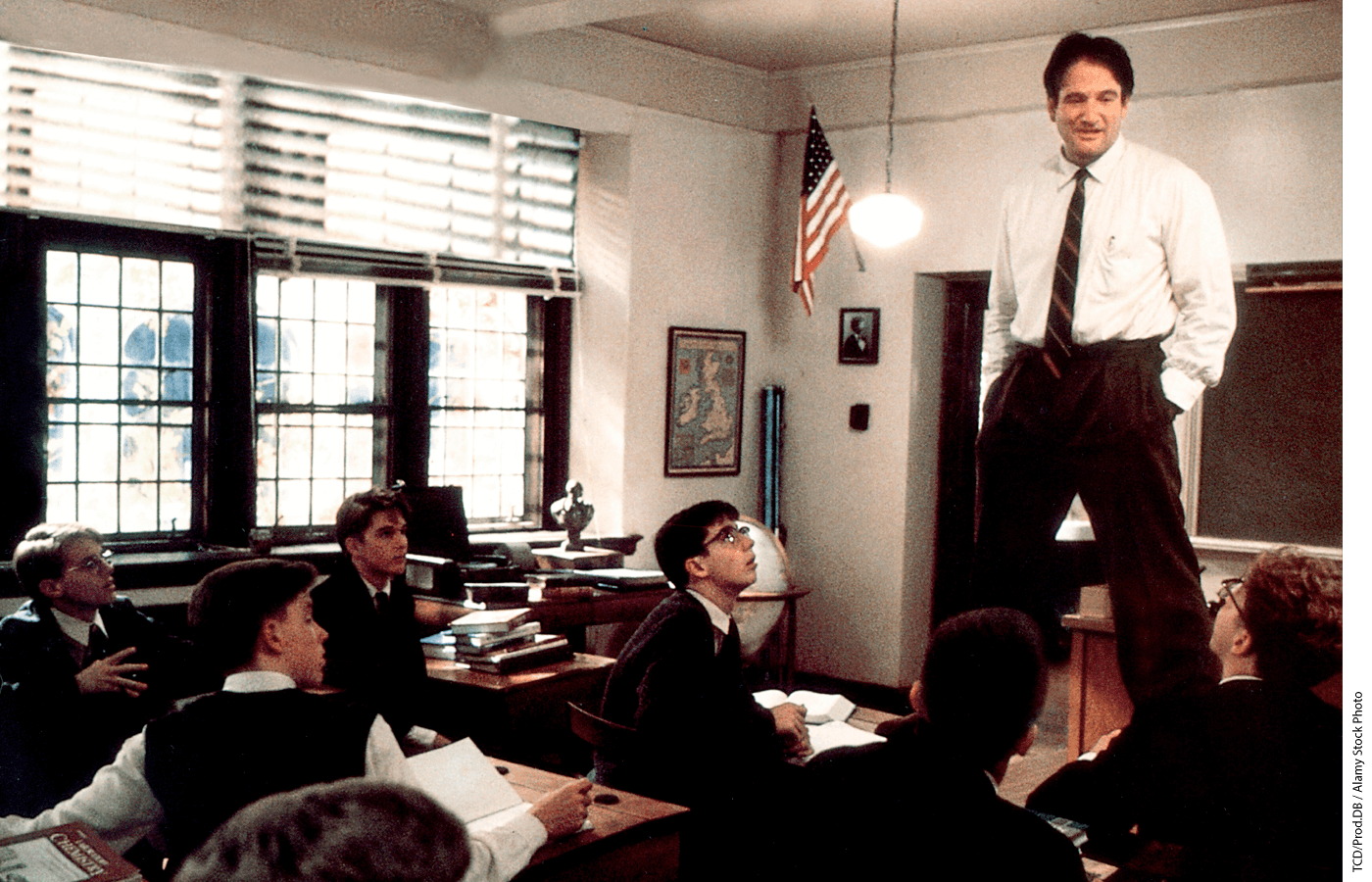 Robin Williams stands on his desk in the film Dead Poets Society