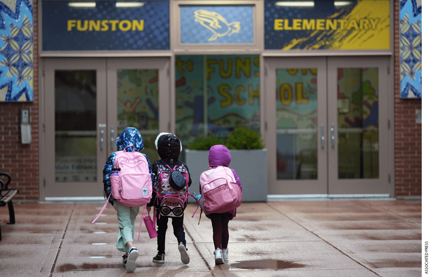 Three sisters, whose single mother fears being mistakenly detained by federal immigration agents because she is of Puerto Rican descent and speaks Spanish, walk into Funston Elementary School in the Logan Square neighborhood of Chicago last October.