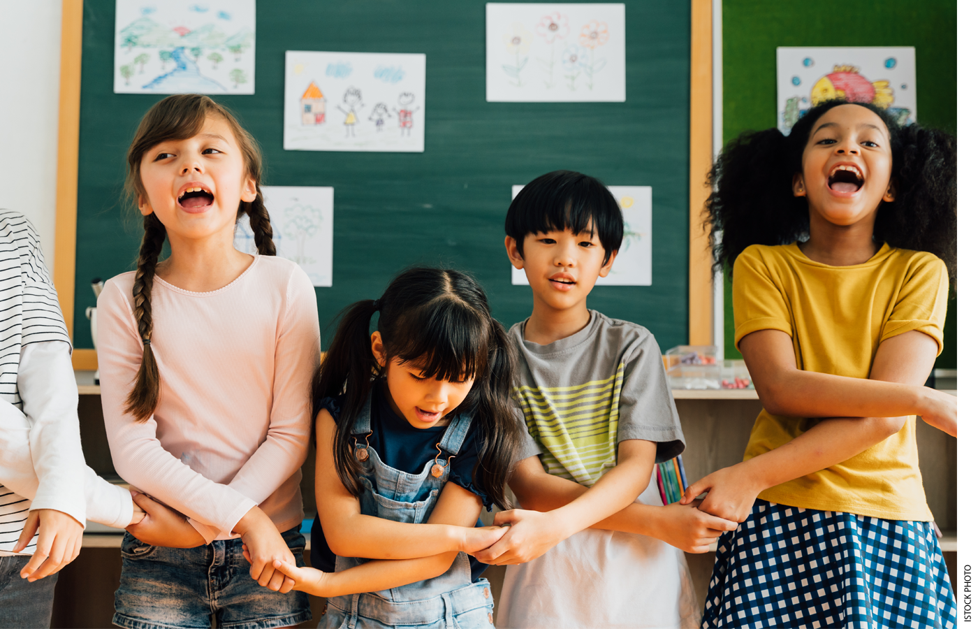 Students holding hands in front of a classroom